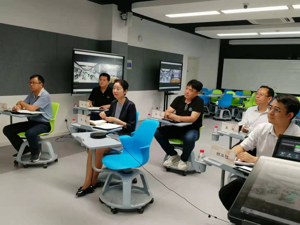 A group of people sitting at desks in a roomDescription automatically generated with medium confidence